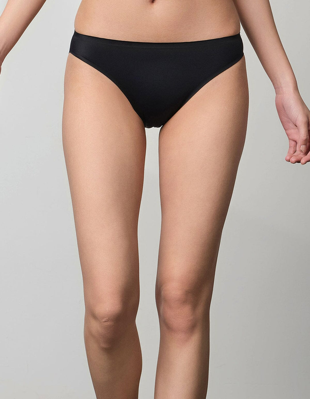 A model is wearing a black SMOOTHING tanga panty