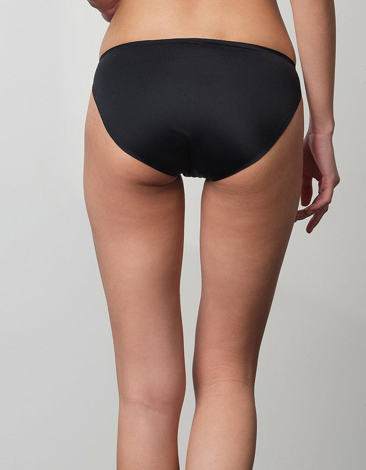 A model is wearing a black SMOOTHING tanga panty