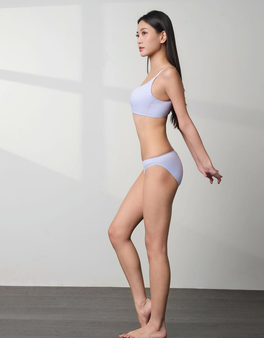 A model is wearing a black SMOOTHING tanga panty